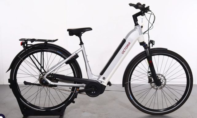 Victoria Tresalo 15 E-Trekking-City (18) E-Bike mit tiefem Einstieg, silberner Rahmen und schwarzem Zubehör.